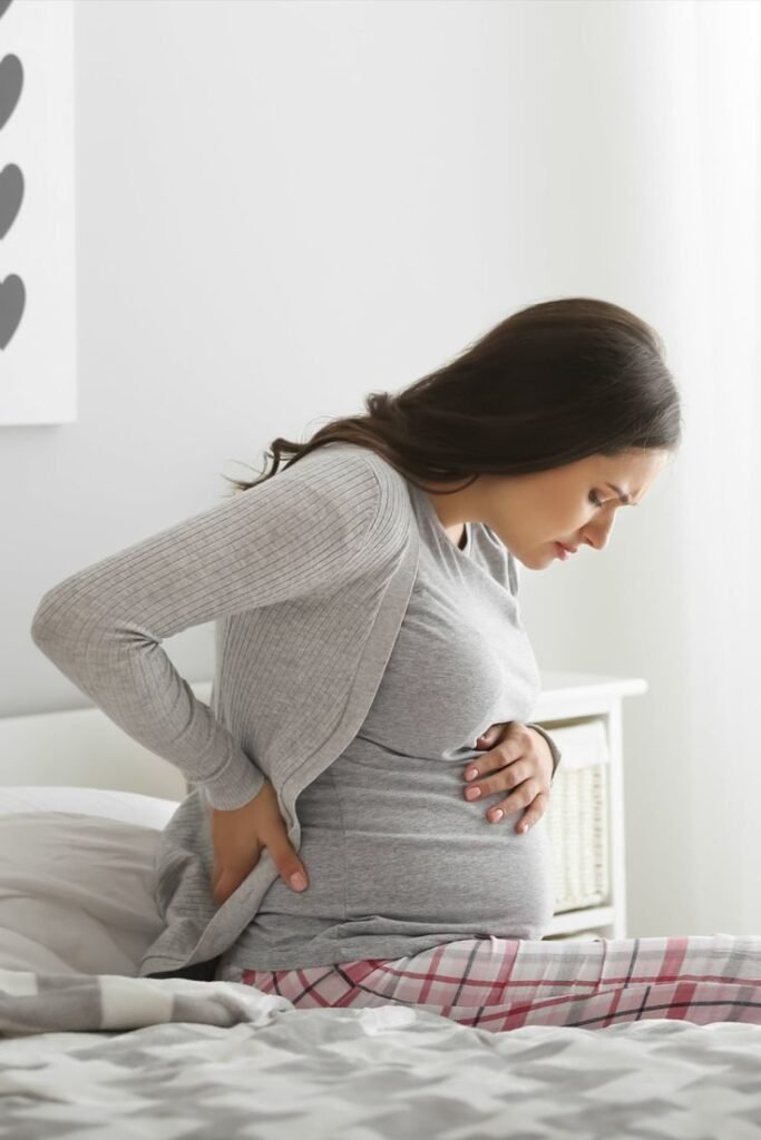 Mulher grávida com dores representando a gestação e indução ao parto